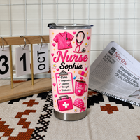 Pink custom nurse tumbler with 'Nurse Sophia' text and medical icons standing upright on a textured rug next to a calendar.
