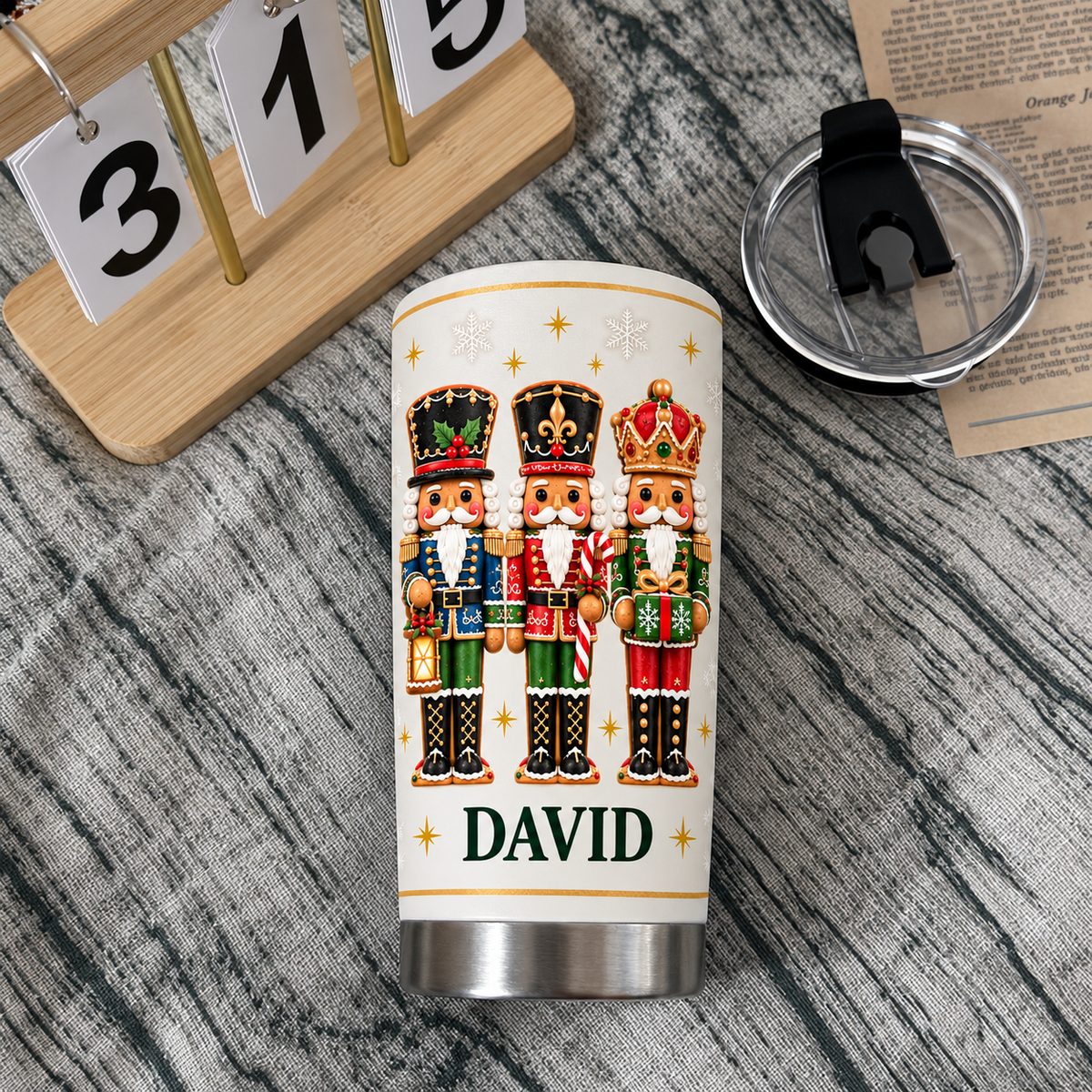 Top-down view of white stainless steel nutcracker Christmas tumbler with name David, black lid, and calendar block