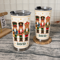 Two personalized white stainless steel nutcracker Christmas tumblers with name David on woven placemat