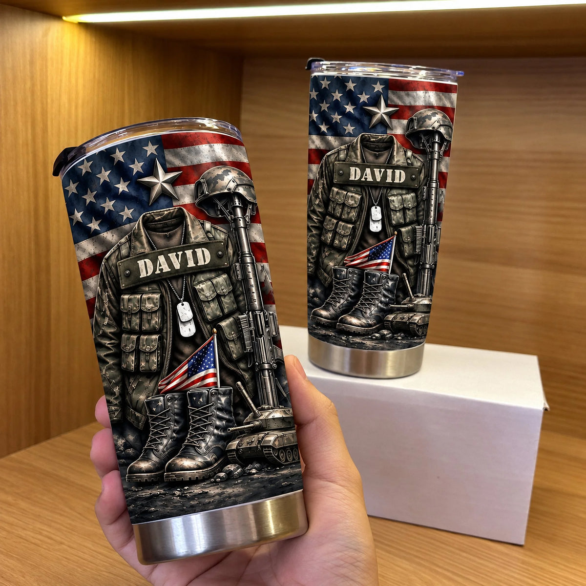 A hand holding a personalized military veteran tumbler displaying a camouflage jacket, dog tags, and helmet graphic.