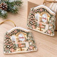 Two personalized Christmas vanity mirror ornaments resting on a wooden surface near a pine branch