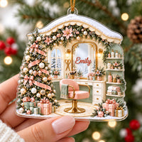House-shaped acrylic ornament with a salon interior, pastel chair, Christmas tree, and the name Emily on the vanity mirror.