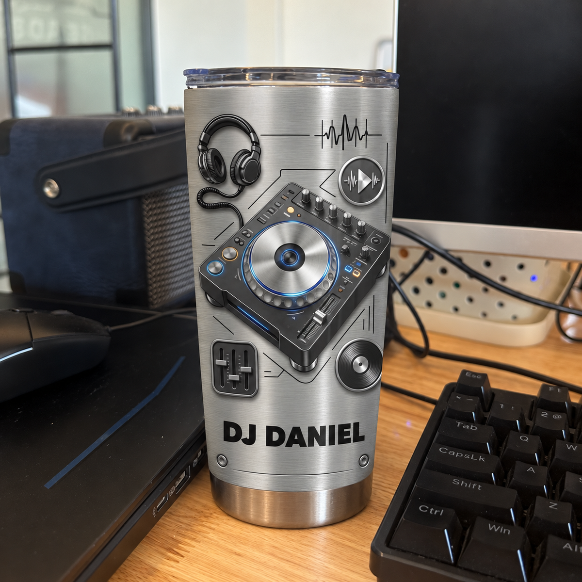 Customized DJ tumbler standing on a wooden desk near a computer keyboard and studio equipment.