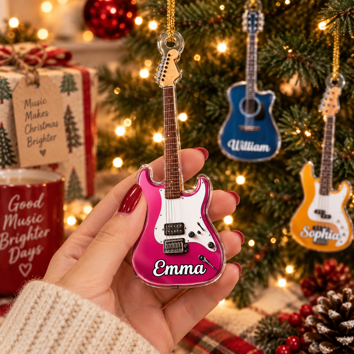 A hand holding a custom pink electric guitar Christmas ornament with the name Emma printed on it.