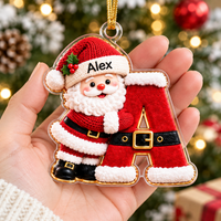 Hand holding a personalized Santa Claus initial letter Christmas ornament with gold hanging cord.