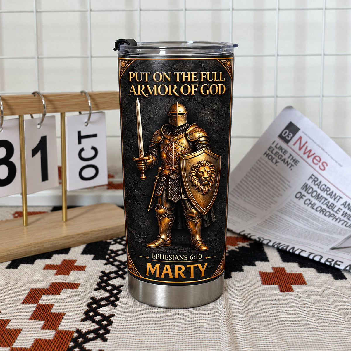 Custom Full Armor Of God tumbler with name Marty on woven mat next to calendar and newspaper