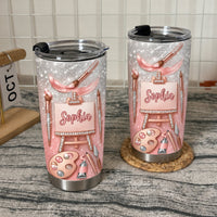 Two custom name artist tumblers standing on a textured surface with a small calendar.