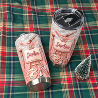 Two personalized tumblers on a green plaid cloth next to a miniature tree.