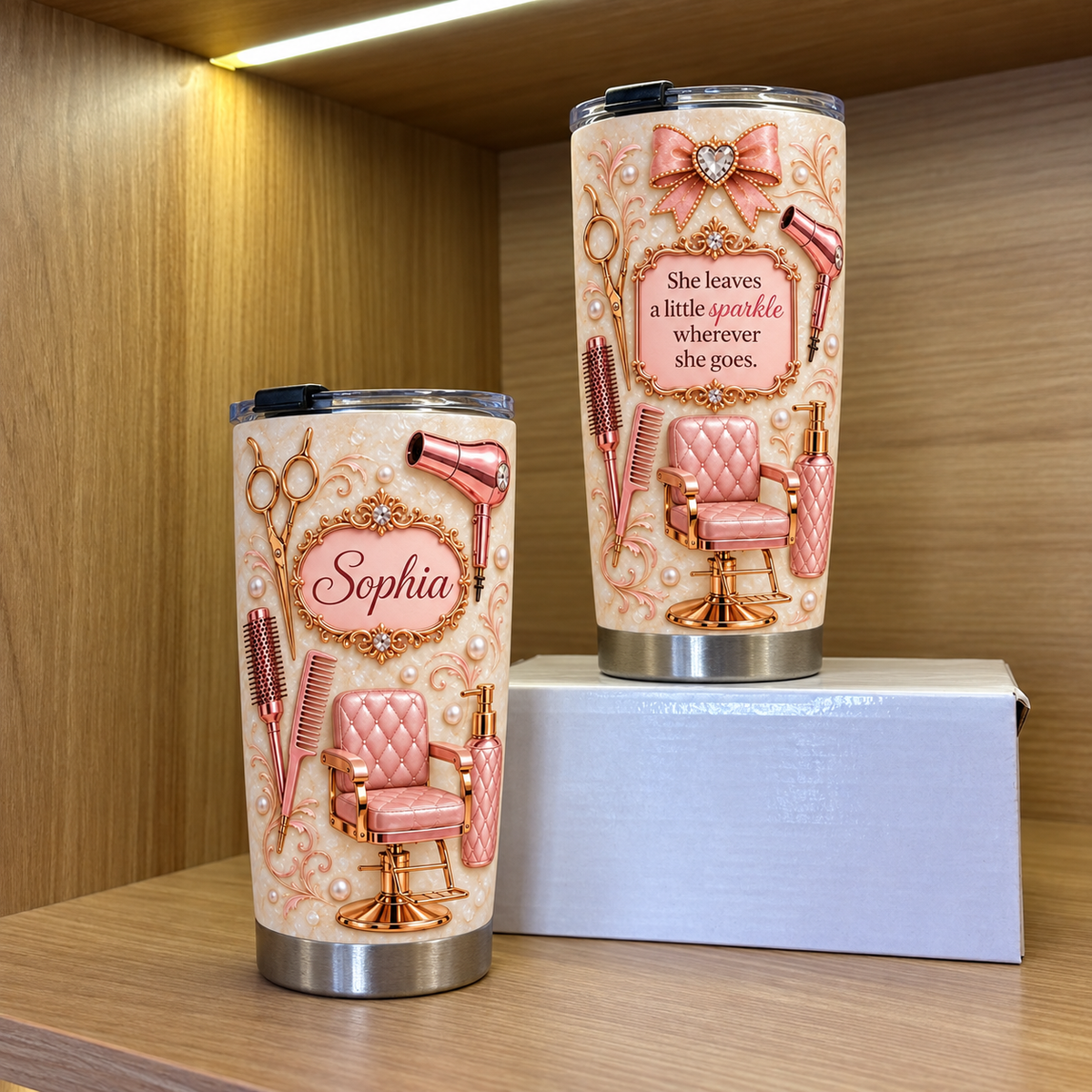 Two custom hair stylist tumblers showing rose gold salon graphics and Sophia name label on wooden shelf with white box.