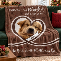Brown memorial fleece throw blanket draped over a green couch with holiday pillows in a cozy living room.
