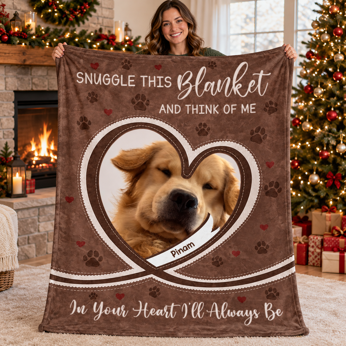 A smiling woman holds up the brown pet memorial fleece blanket with a dog photo inside a heart frame.