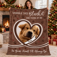 A smiling woman holds up the brown pet memorial fleece blanket with a dog photo inside a heart frame.