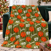 An olive green basketball pattern blanket with name James and number 07 spread out on a green sofa.