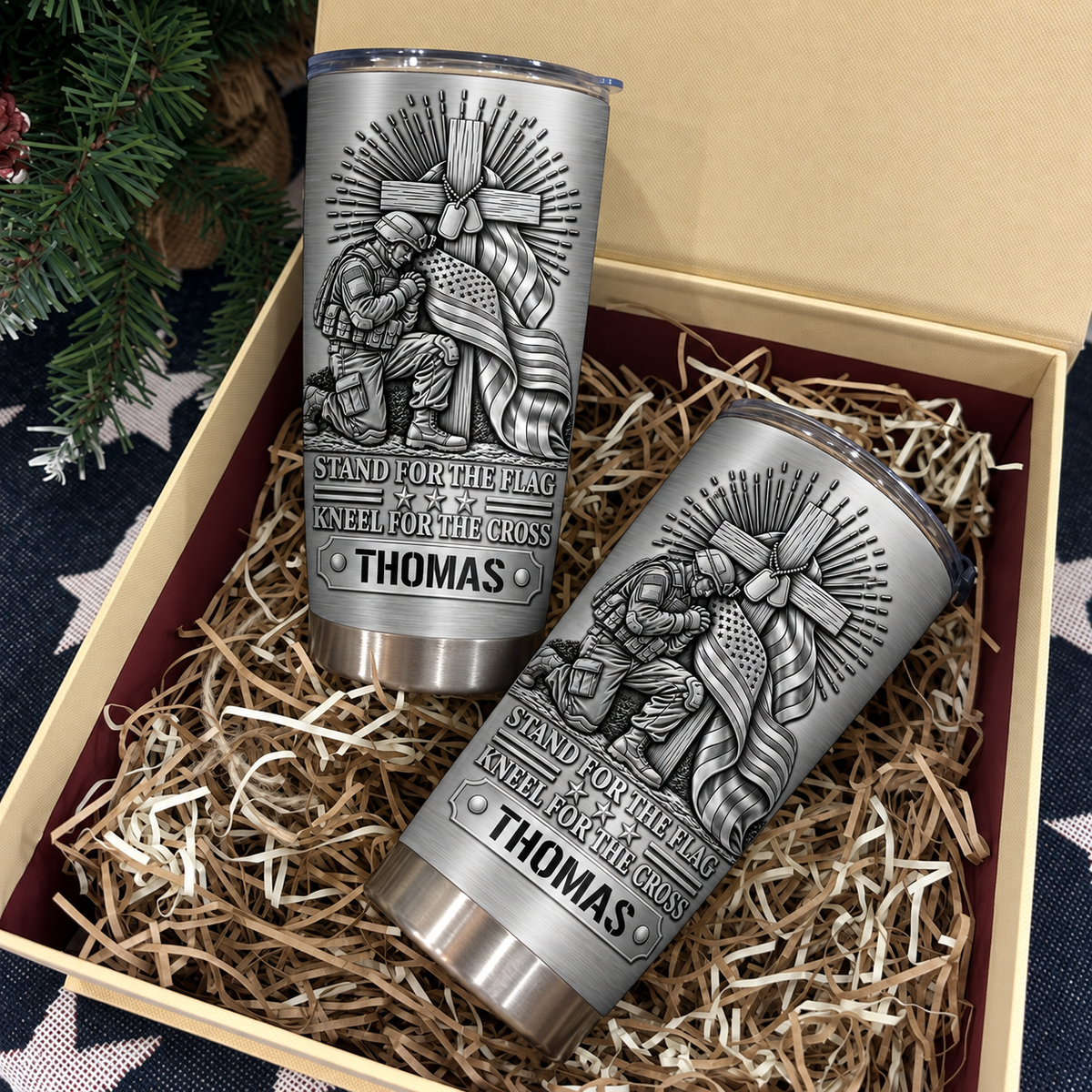 Two personalized stainless steel travel mugs inside a gift box with shredded paper.
