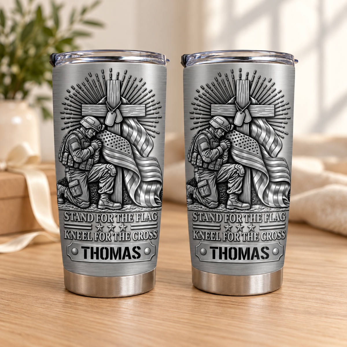 Two stainless steel travel mugs with military veteran gift design on a wooden table.
