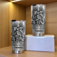 Two Christian patriotic tumblers on a wooden shelf next to a small white box.