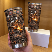 Hand holding steampunk welder tumbler with second tumbler on white box in wooden display.