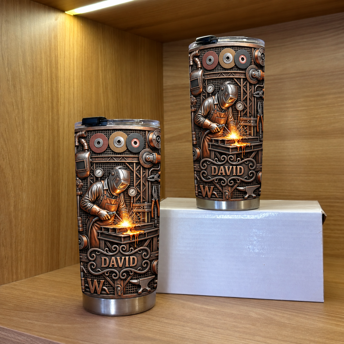 Two steampunk welder tumblers with custom name David on wooden shelf against wood background.