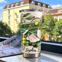 Personalized sports drinkware gift tumbler displayed on a wooden surface in front of an apartment building.