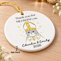Round ceramic cat ornament on wooden surface with arrow pointing to its 3mm thickness.