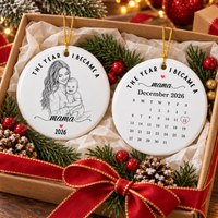 The personalized ceramic ornament presented inside a gift box decorated with pine needles and a red bow.