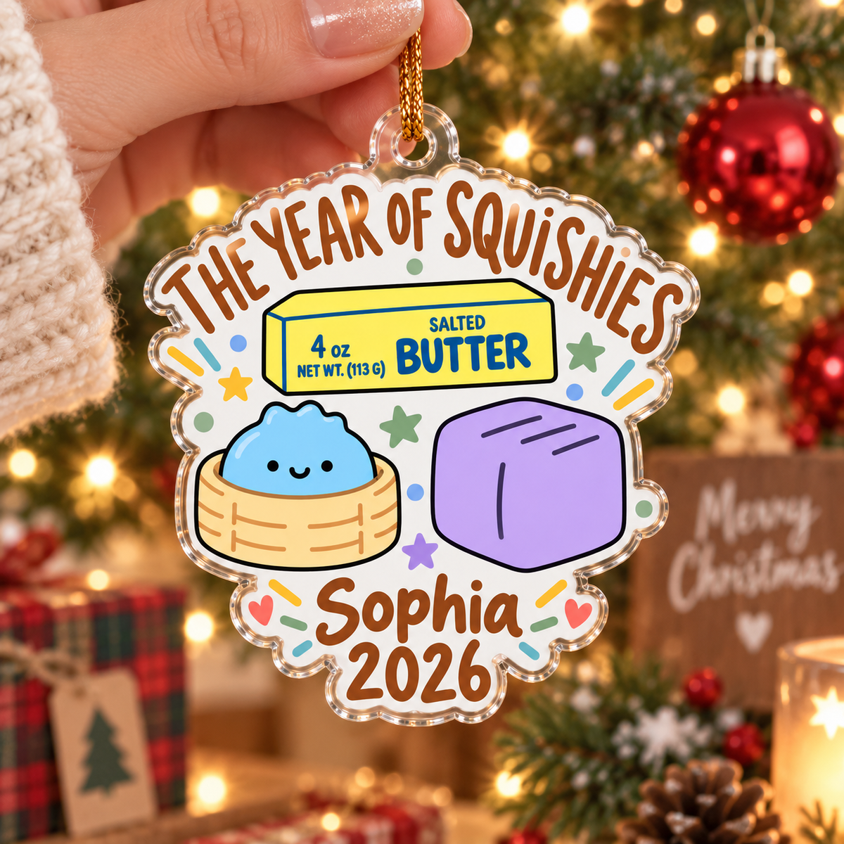 Hand holding clear acrylic squishy ornament with personalized name and 2026 text.