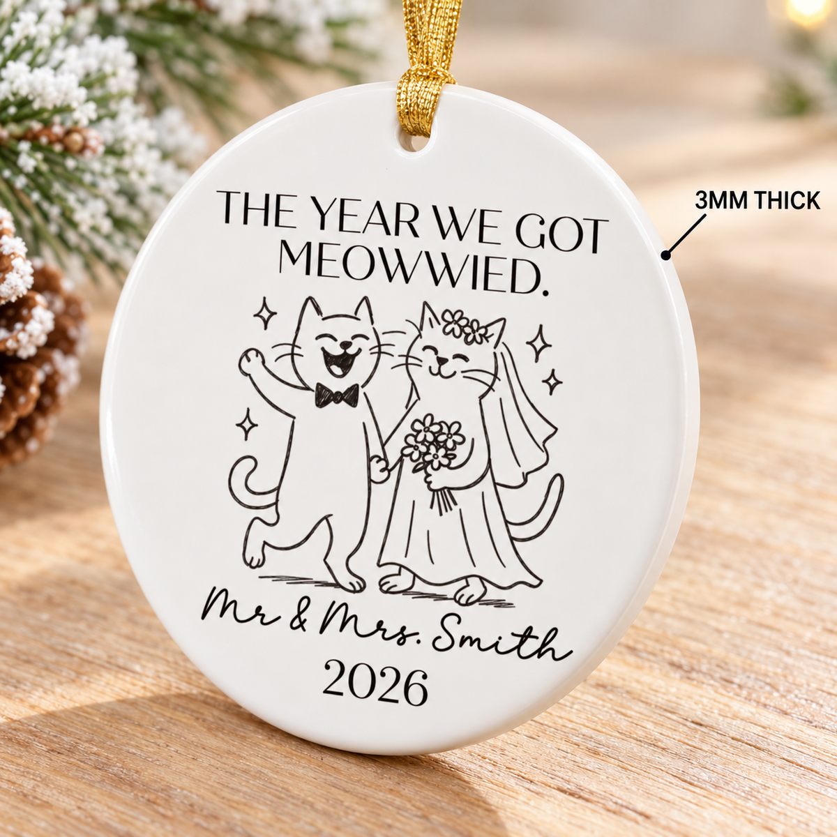 Ceramic cat wedding ornament angled on a wooden surface with a 3mm thickness pointer.