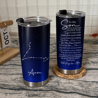 Two stainless steel tumblers with son birthday gift quote and constellation design stand on a wooden surface.