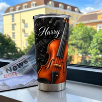 Personalized violin music tumbler standing upright on a white surface near a window with a newspaper backdrop.