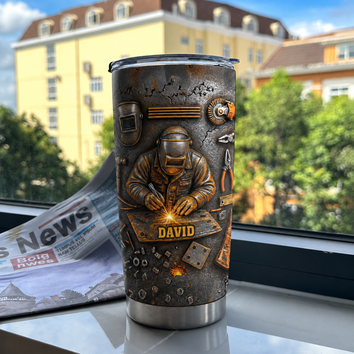 Welder personalized tumbler featuring a metalworker graphic next to a newspaper on a windowsill.