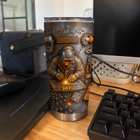 Custom name welder personalized tumbler standing on a desk beside a computer keyboard.