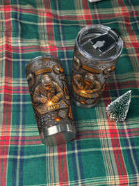 Two welder personalized tumblers with custom name displayed on a green plaid blanket with mini tree.