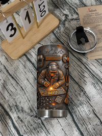 Welder personalized tumbler with custom name lying on a wooden surface next to a calendar.