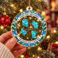 A hand holding a round clear acrylic Christmas ornament featuring connected state outlines and a quote.