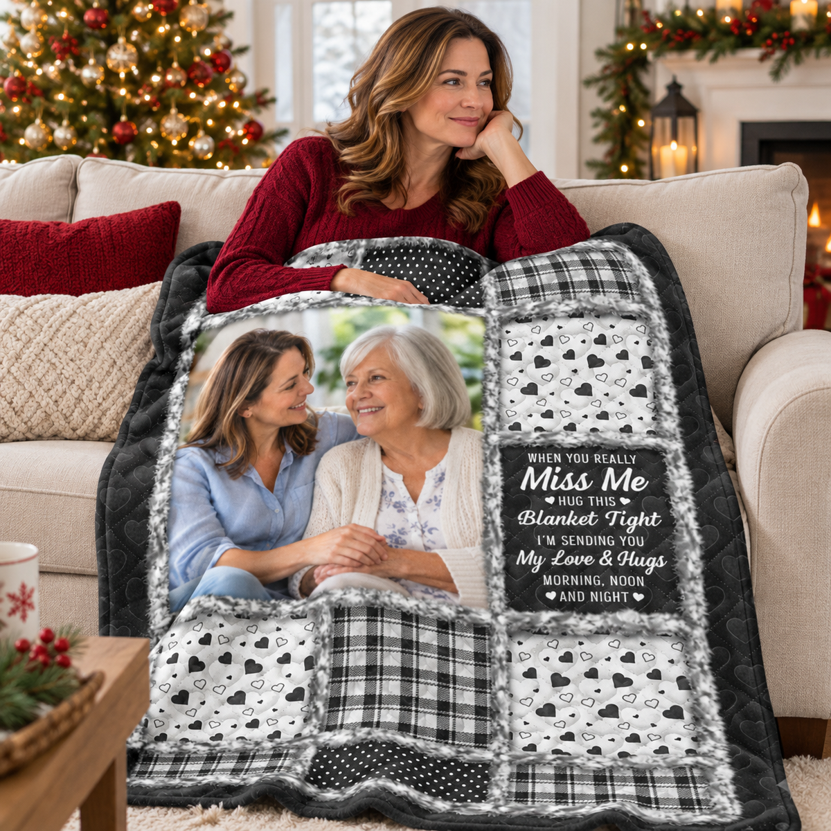 Woman relaxing on a couch with a hug this blanket tight quilt featuring black and white patchwork and family photos.