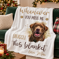A custom dog name blanket displayed on a green sofa with decorative pillows and wrapped gifts nearby.