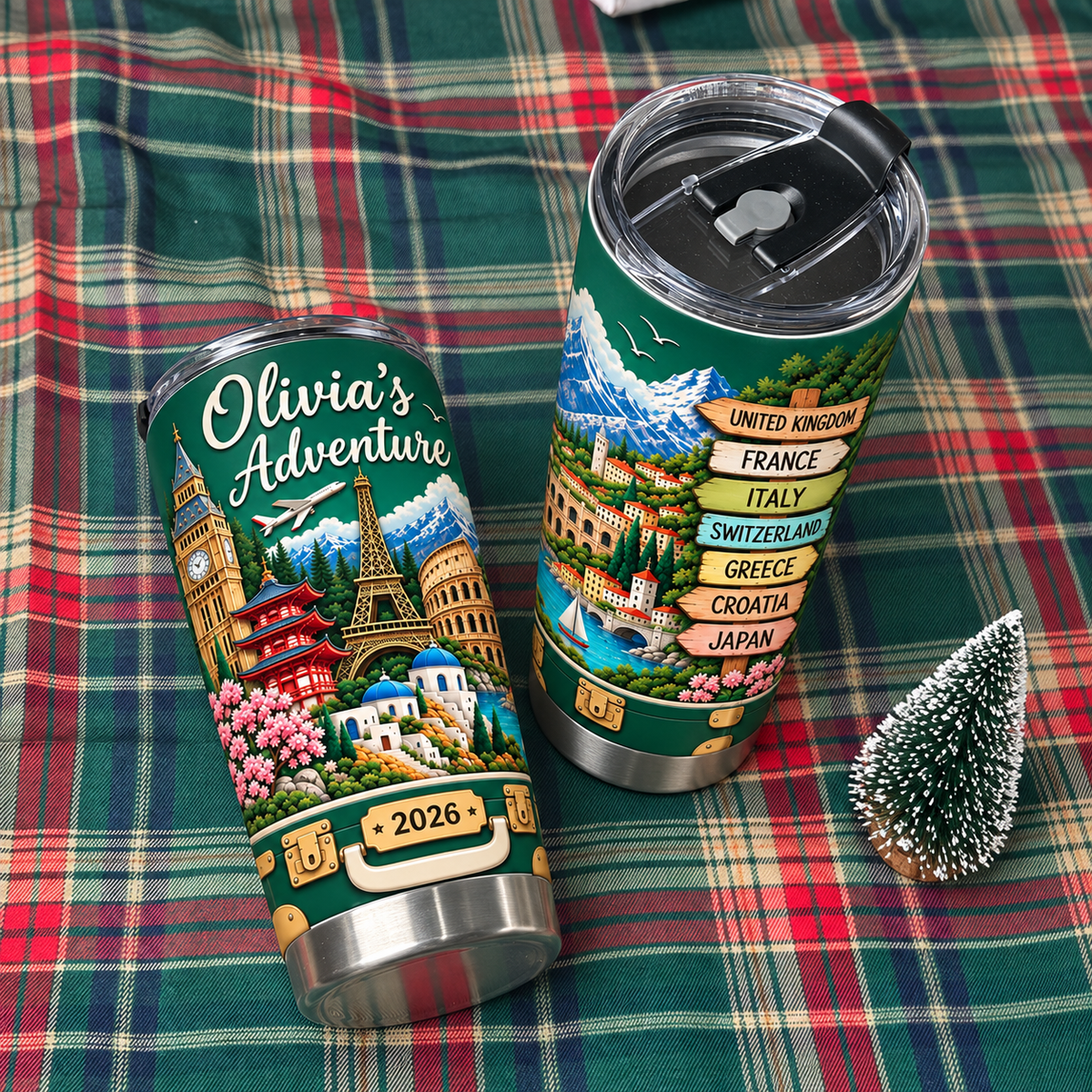 World Travel Landmarks Tumbler lying on a green plaid blanket beside a miniature holiday tree figurine.