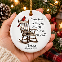 Hand holding a personalized bereavement gift ornament against a backdrop of glowing holiday lights.