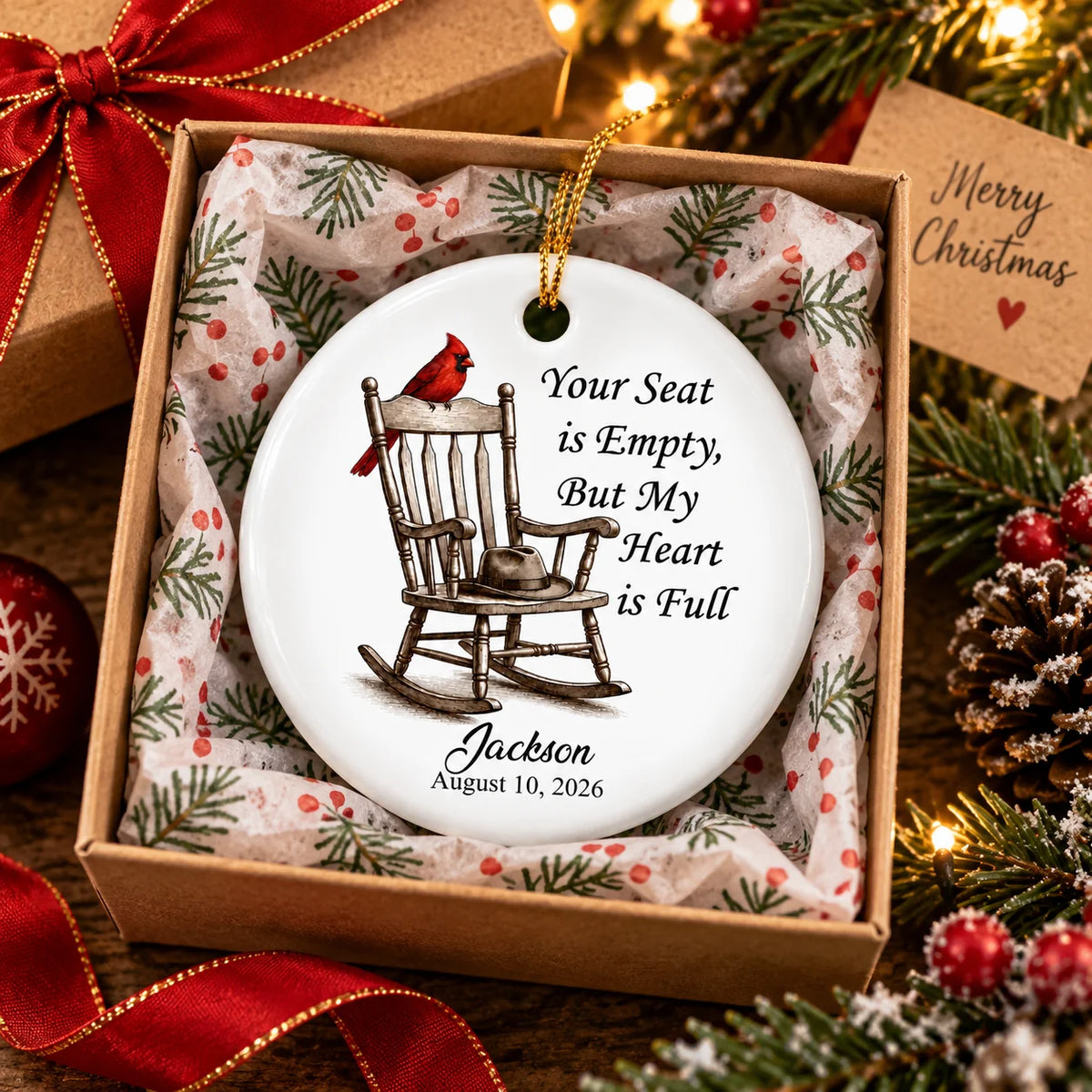Custom memorial ornament resting inside a gift box filled with holiday tissue paper and pinecones.